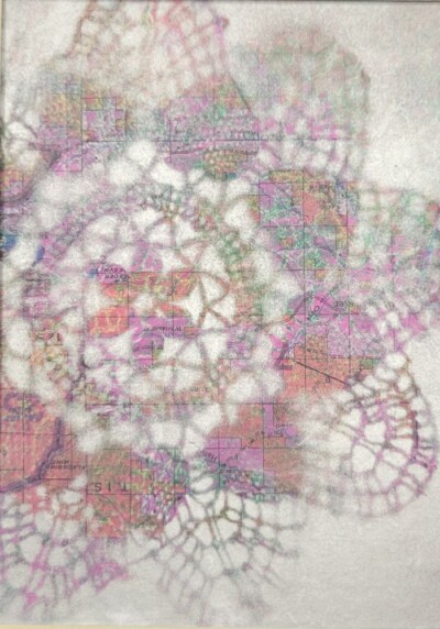 Doily monoprint on top of a map, white tones